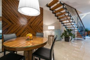 a dining room with a wooden table and a staircase at Apartment on the Main Street with Parking Old Town in Košice