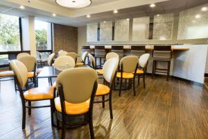 une salle d'attente avec des chaises, des tables et un bar dans l'établissement Drury Inn & Suites Austin North, à Austin