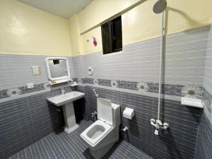 a bathroom with a toilet and a sink at Hotel Rooms DHA in Karachi