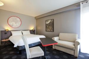 Habitación de hotel con cama y silla en ibis Styles Paris Mairie de Montreuil, en Montreuil