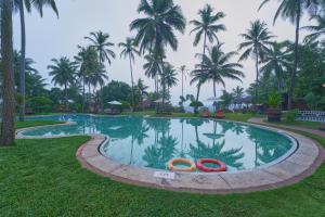 ein Schwimmbad mit zwei orangenen Röhren im Gras in der Unterkunft The Raviz Kadavu, Kozhikode in Kozhikode