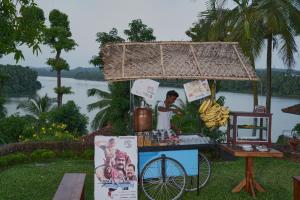 Ein Imbiss mit einem Mann, der neben einem Fahrrad steht. in der Unterkunft The Raviz Kadavu, Kozhikode in Kozhikode