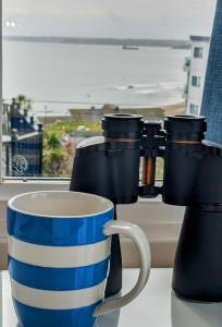 une tasse de café bleue et blanche assise sur une table dans l'établissement The Westcott by the Sea - Just for Adults, à Falmouth