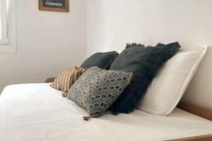 a white couch with black pillows on it at Can Estrellas, appartement d'exception sur la mer in Roses