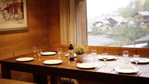 uma mesa de madeira com uma garrafa de vinho e copos em Chalet Mimi em Morzine