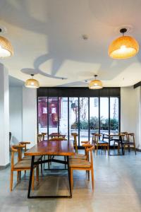 a dining room with tables and chairs and windows at Lijiang Gemmer Hotel in Lijiang