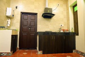 uma cozinha com um lavatório e uma porta castanha em Heritage home with 2 bed/2 bath with kitchen in a residential neighborhood. em Madurai