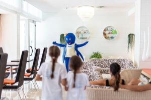 eine Gruppe von Kindern, die einen Charakter im Wohnzimmer beobachten in der Unterkunft Hotel Las Vegas in Bibione