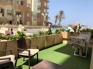 a patio with green grass and chairs and a pool at Magnifique s2 avec une vue sur mer in Hammam Sousse