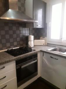 a kitchen with a stove top oven next to a sink at Magnifique s2 avec une vue sur mer in Hammam Sousse