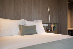 a bedroom with a bed with white sheets and pillows at Watts House in Seia