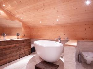 baño con bañera grande y aseo en Chalet Chalet Le Haut Pré by Interhome, en Villars-sur-Ollon