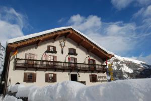 ein Gebäude mit Balkon auf Schnee in der Unterkunft Hotel Des Glaciers in Courmayeur