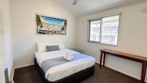 a small bedroom with a bed and a window at Torquay Hotel/Motel in Torquay