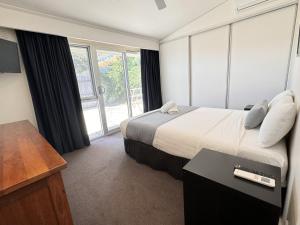 a hotel room with a bed and a large window at Torquay Hotel/Motel in Torquay