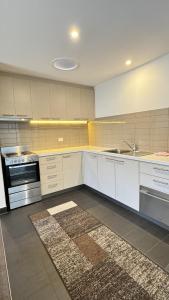 a kitchen with white cabinets and a sink and a stove at Torquay Hotel/Motel in Torquay