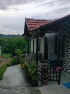 ein kleines Haus mit einer Bank und einer Veranda in der Unterkunft Dreamwood FarmStay in Hassan