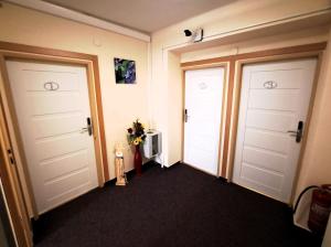 a hallway with two doors and a television at Alcorso Pension in Banská Bystrica