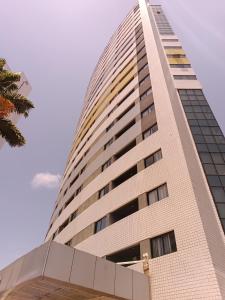 un edificio alto con un cielo blu sullo sfondo di Suíte acolhedora em Hotel a Natal