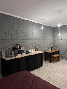 a kitchen with a sink and a counter with a microwave at Luxury Live in Kamianets-Podilskyi