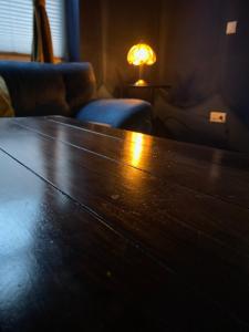 a large wooden table in a room with a lamp at Blue Royal Apartment in Celle