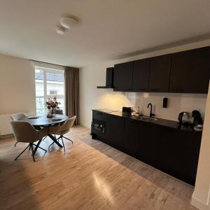 een keuken met een tafel en stoelen in een kamer bij The Residence Apeldoorn in Apeldoorn