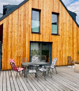 une terrasse en bois avec une table et des chaises dans l'établissement Harrachov 702, à Harrachov