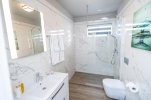 a white bathroom with a sink and a shower at Guesthouse Keflavik by Reykjavik Keflavik Airport in Keflavík