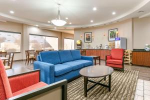 ein Wohnzimmer mit einem blauen Sofa und roten Stühlen in der Unterkunft Comfort Inn & Suites Van Buren - Fort Smith in Van Buren