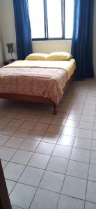 a bed sitting on a tiled floor in a room at Hostal Iberia in Talara