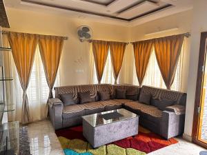 un soggiorno con divano e tavolo di DEEYA Guest House - A Luxury Home Stay a Mysore