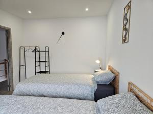 een slaapkamer met 2 bedden en een spiegel aan de muur bij Appart'Hôtel Trazegnies in Courcelles