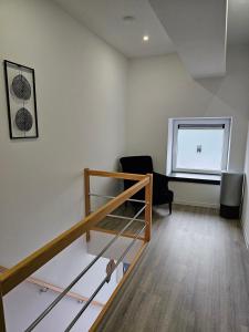 een kamer met een trap, een stoel en een raam bij Appart'Hôtel Trazegnies in Courcelles