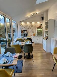 una sala da pranzo con tavoli e sedie e una cucina di Hôtel Coeur De Loire a Nantes