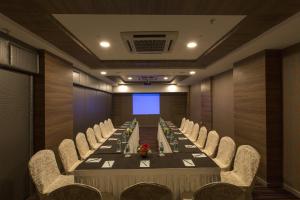 a conference room with a long table and chairs at The President Hotel in Hubli