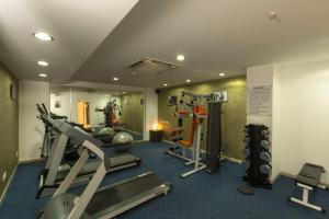 a gym with cardio equipment in a room at The President Hotel in Hubli