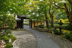 une passerelle dans un parc arboré et un bâtiment dans l'établissement Suiran, a Luxury Collection Hotel, Kyoto, à Kyoto