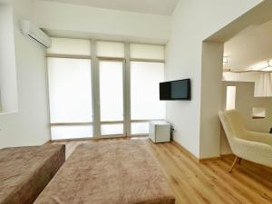 1 dormitorio con 1 cama, TV y silla en Higina Spa Hotel, en Truskavets