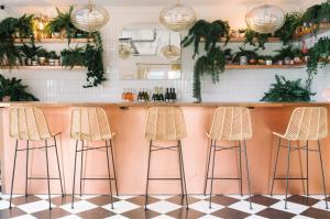 a bar with stools in a kitchen with plants at The June Motel, Prince Edward County in Picton