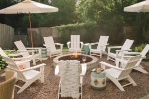 a group of white chairs and a fire pit in a yard at The June Motel, Prince Edward County in Picton