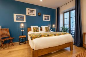 a bedroom with a bed and a blue wall at Escale Rochelaise, chambre avec acces toute l'année au sauna et SPA chauffée in La Rochelle