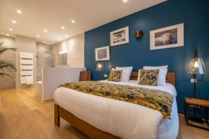 a bedroom with a large bed and a blue wall at Escale Rochelaise, chambre avec acces toute l'année au sauna et SPA chauffée in La Rochelle