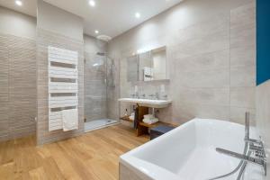 a bathroom with a white tub and a sink at Escale Rochelaise, chambre avec acces toute l'année au sauna et SPA chauffée in La Rochelle