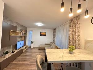 een woonkamer met een tafel en een bank bij Deluxe Cozy Apartments - Coresi Mall #Brasov in Braşov