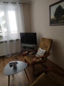 een woonkamer met een stoel en een tafel bij Emilka in Suwałki