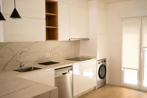 a white kitchen with a sink and a dishwasher at Apartamento NUEVO en el centro de LEON in León