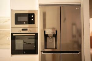 a kitchen with a refrigerator and a microwave at Apartamento NUEVO en el centro de LEON in León