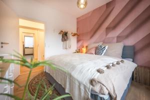 - une chambre avec un grand lit et un mur rayé dans l'établissement 120qm, cozy Apartment, sehr zentral am HBF, 3SZ, à Coblence