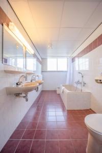 La salle de bains est pourvue de 2 lavabos, d'une baignoire et de toilettes. dans l'établissement Fletcher Hotel-Restaurant Waalwijk, à Waalwijk