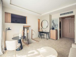 uma sala de estar com uma mesa e um espelho em Mercure Troyes Centre em Troyes